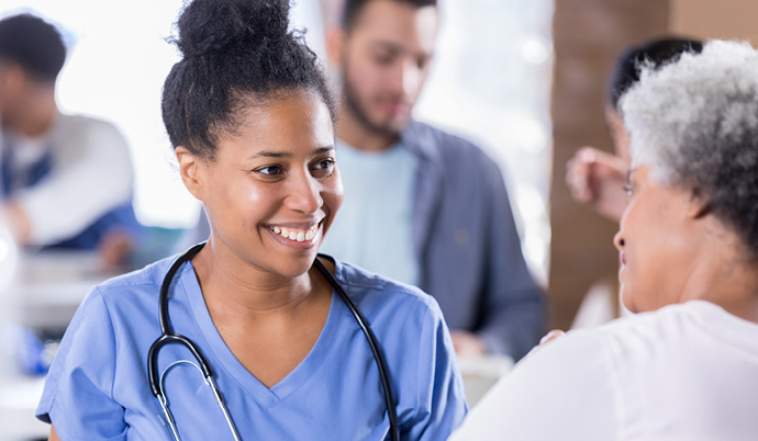 nurse and older patient talking and smiling