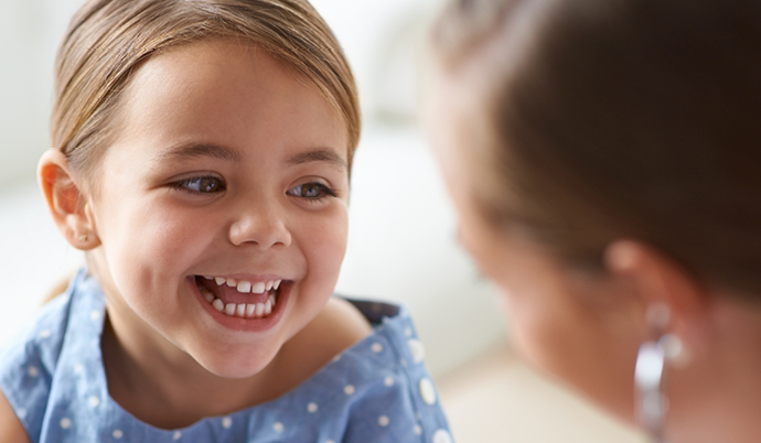 little girl smiling at her doctor