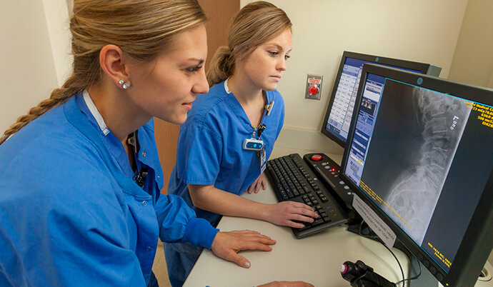 nurses looking at a scan on a computer screen