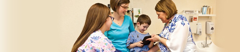 doctor showing a little boy something on a tablet