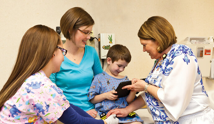 doctor talking to a little boy and his family