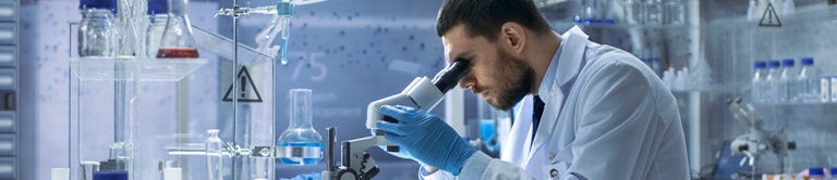 scientist looking through a microscope
