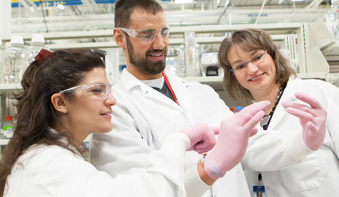 scientists holding up a slide to examine