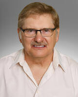 Alan Fehr in white shirt with glasses, short hair, and mustache
