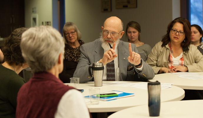 Several people listening to someone talk.