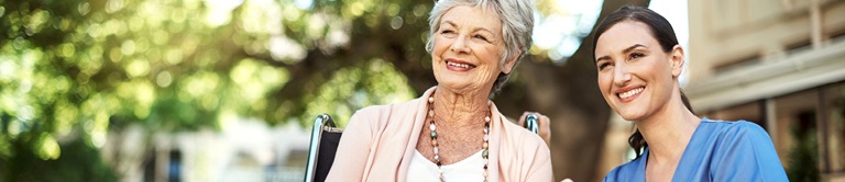 nurse sitting with woman outside nursing home