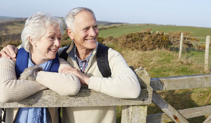 couple leaning on a fence outside