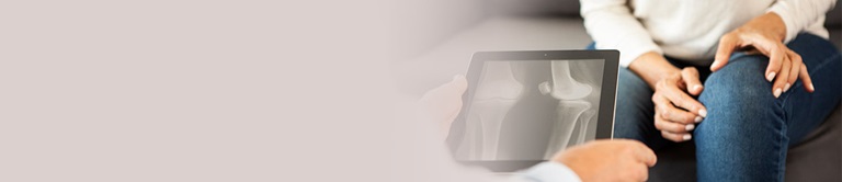 Doctor examining knee x-ray with patient