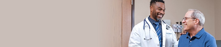 Doctor with his hand on a patient's shoulder.