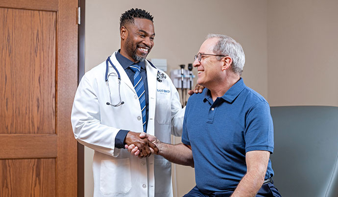 Doctor shaking a patient's hand during check-up.