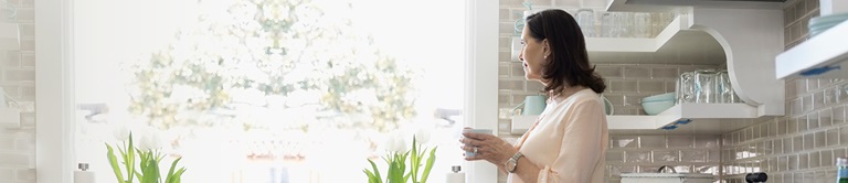 woman in kitchen looking outside